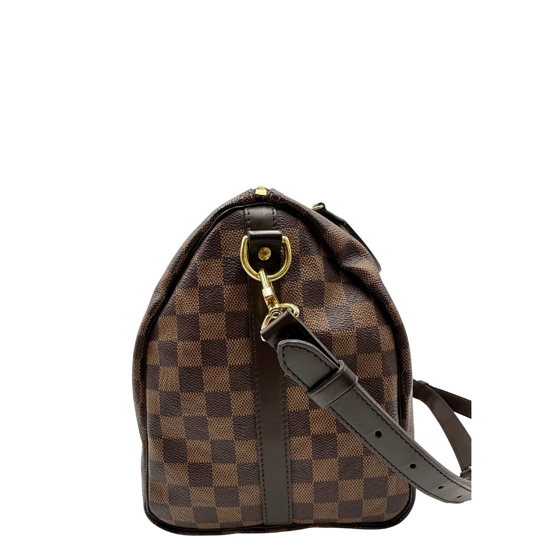 lato Borsa Speedy 35 in canvas Damier Ébène marrone con finiture in pelle marrone e parti metalliche dorate; munita di una tracolla amovibile e regolabile e doppi manici stondati. Completa di scatola, lucchetto e chiavi, di lusso, originale, usata. 