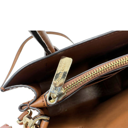 Borsa Michael Kors in pelle color cammello con parti metalliche dorate; munita di doppi manici e una tracolla amovibile e regolabile, impreziosita da borchie piramidali, di lusso, originale, ottime condizioni.