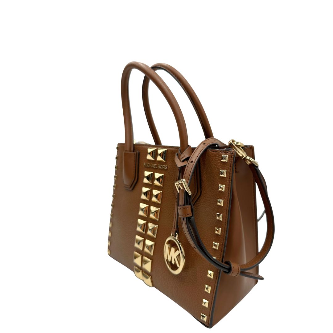 lato Borsa Michael Kors in pelle color cammello con parti metalliche dorate; munita di doppi manici e una tracolla amovibile e regolabile, impreziosita da borchie piramidali, di lusso, originale, ottime condizioni.