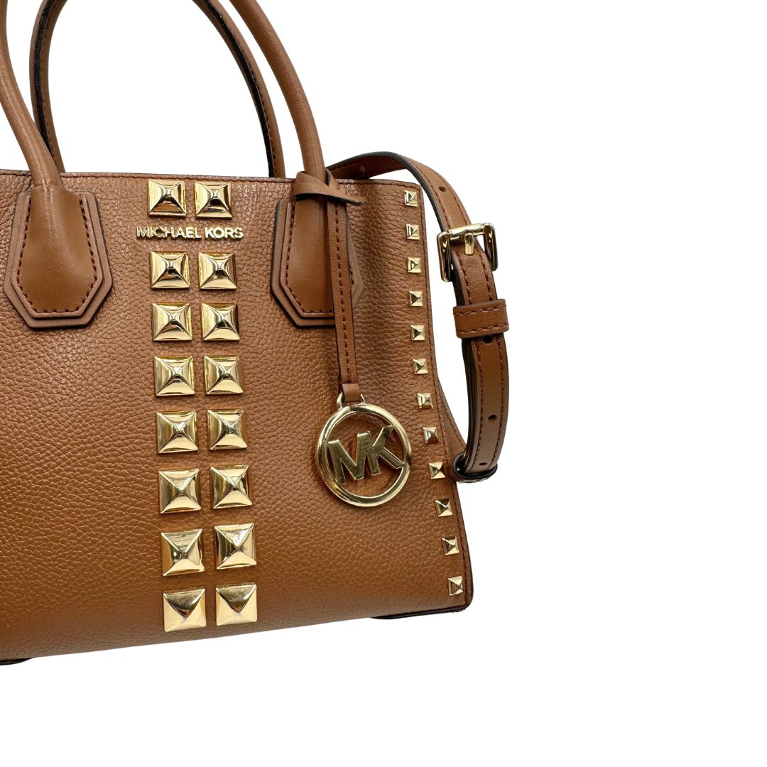 Borsa Michael Kors in pelle color cammello con parti metalliche dorate; munita di doppi manici e una tracolla amovibile e regolabile, impreziosita da borchie piramidali, di lusso, originale, ottime condizioni.