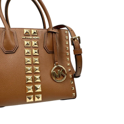 Borsa Michael Kors in pelle color cammello con parti metalliche dorate; munita di doppi manici e una tracolla amovibile e regolabile, impreziosita da borchie piramidali, di lusso, originale, ottime condizioni.