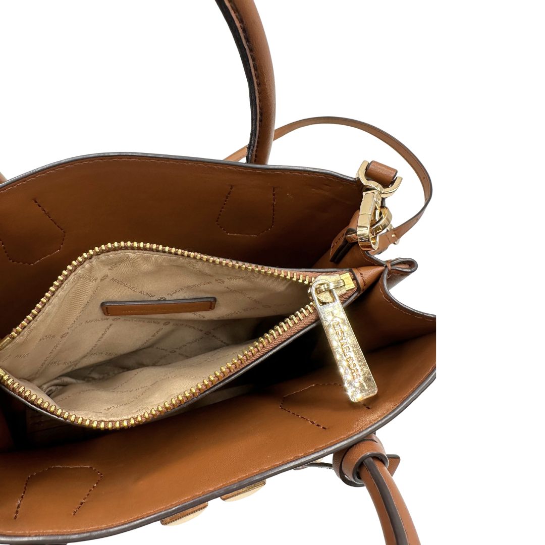 interno Borsa Michael Kors in pelle color cammello con parti metalliche dorate; munita di doppi manici e una tracolla amovibile e regolabile, impreziosita da borchie piramidali, di lusso, originale, ottime condizioni.