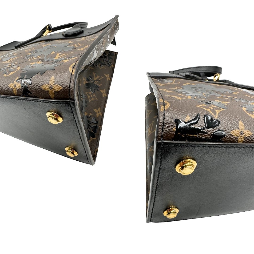 angoli Borsa Louis Vuitton L.E. in canvas marrone monogram con finiture in pelle nera e parti metalliche dorate, impreziosita da motivo decorativo floreale verniciato nero e un porta address amovibile; munita di doppi manici stondati e una tracolla amovibile. Completa di dustbag, di lusso, originale, ottime condizioni. 