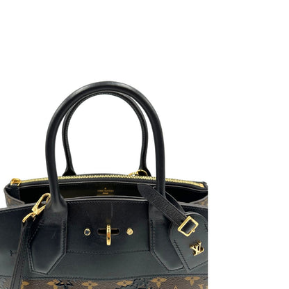 manici Borsa Louis Vuitton L.E. in canvas marrone monogram con finiture in pelle nera e parti metalliche dorate, impreziosita da motivo decorativo floreale verniciato nero e un porta address amovibile; munita di doppi manici stondati e una tracolla amovibile. Completa di dustbag, di lusso, originale, ottime condizioni.