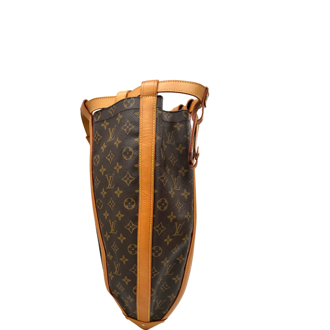 Lato destro di un Zaino Louis Vuitton in canvas marrone monogram con finiture in vacchetta naturale e parti metalliche dorate; munita di un cinturino centrale con fibbia e un manico amovibili. Indossabile a spalla. Completa di dustbag. Originale, usata, di lusso, in ottime condizioni.