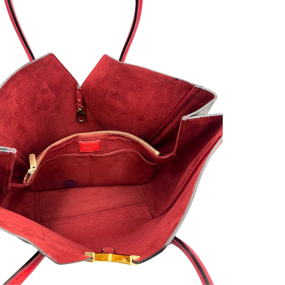 Interno di una borsa Louis Vuitton modello Kimono Tote, in canvas monogram e pelle rossa.
Struttura con pannelli incrociati e inserto frontale con elemento metallico a forma di V in finitura dorata. Manici superiori in pelle. Dotata di dustbag. Indossabile a spalla.