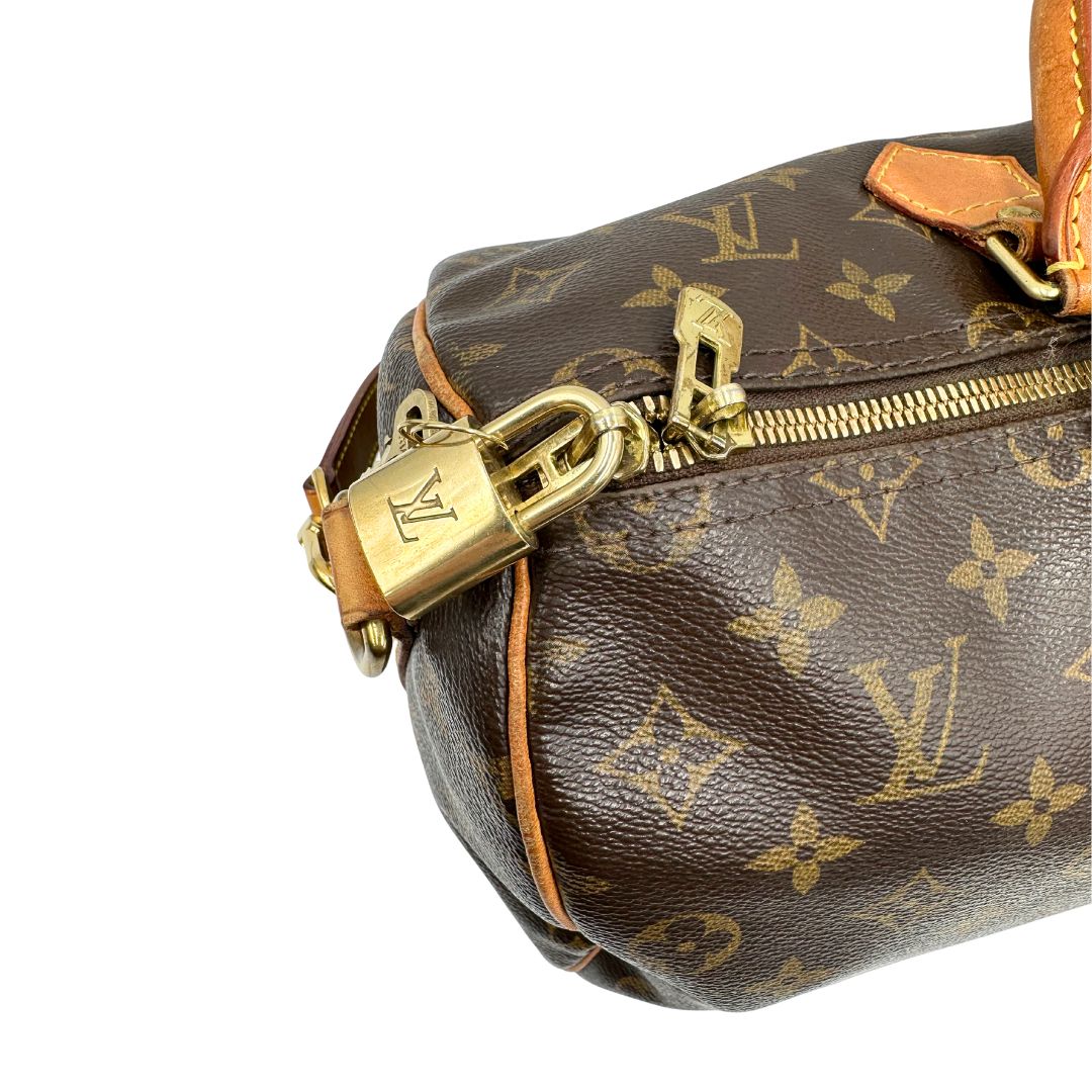 Chiusura di una Borsa Speedy 35 in canvas marrone monogram con finiture in vacchetta naturale e parti metalliche dorate; munita di doppi manici stondati e una tracolla amovibile e regolabile. Completa di lucchetto e chiavi. Originale, usato, di lusso, in ottime condizioni.