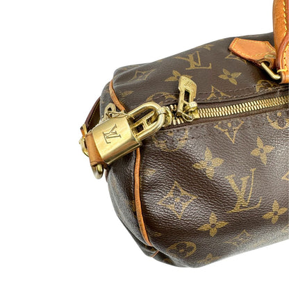 Chiusura di una Borsa Speedy 35 in canvas marrone monogram con finiture in vacchetta naturale e parti metalliche dorate; munita di doppi manici stondati e una tracolla amovibile e regolabile. Completa di lucchetto e chiavi. Originale, usato, di lusso, in ottime condizioni.
