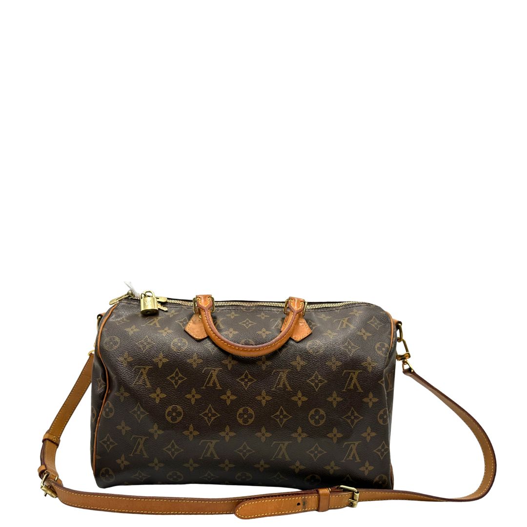 Retro di una Borsa Speedy 35 in canvas marrone monogram con finiture in vacchetta naturale e parti metalliche dorate; munita di doppi manici stondati e una tracolla amovibile e regolabile. Completa di lucchetto e chiavi. Originale, usato, di lusso, in ottime condizioni.