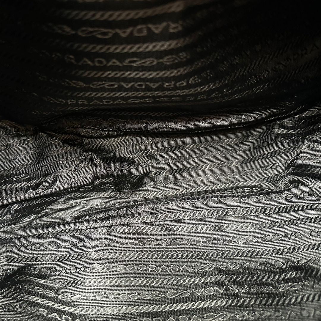 interno Borsa Prada in nylon nero con finiture in pelle tono su tono e parti metalliche argentate; munita di una tracolla regolabile in tessuto, di lusso, originale, ottime condizioni, usata.