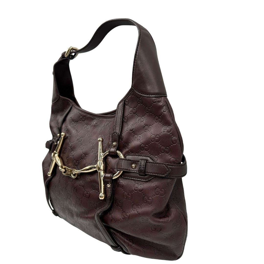 lato Borsa Gucci in pelle GG color vinaccia con parti metalliche dorate; munita di un manico singolo e impreziosita da dettaglio Horsebit sul front. Completa di dustbag, di lusso, originale, ottime condizioni. 