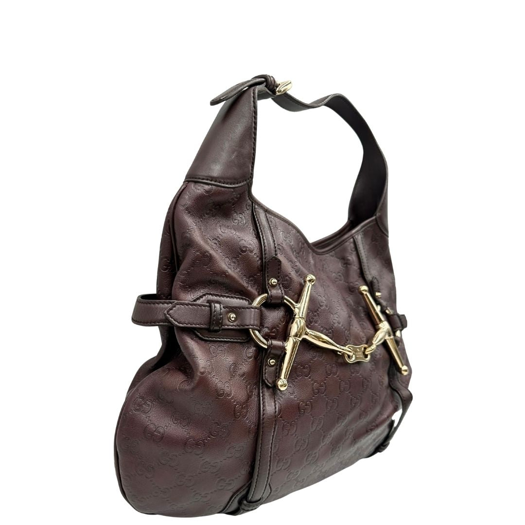 lato Borsa Gucci in pelle GG color vinaccia con parti metalliche dorate; munita di un manico singolo e impreziosita da dettaglio Horsebit sul front. Completa di dustbag, di lusso, originale, ottime condizioni. 