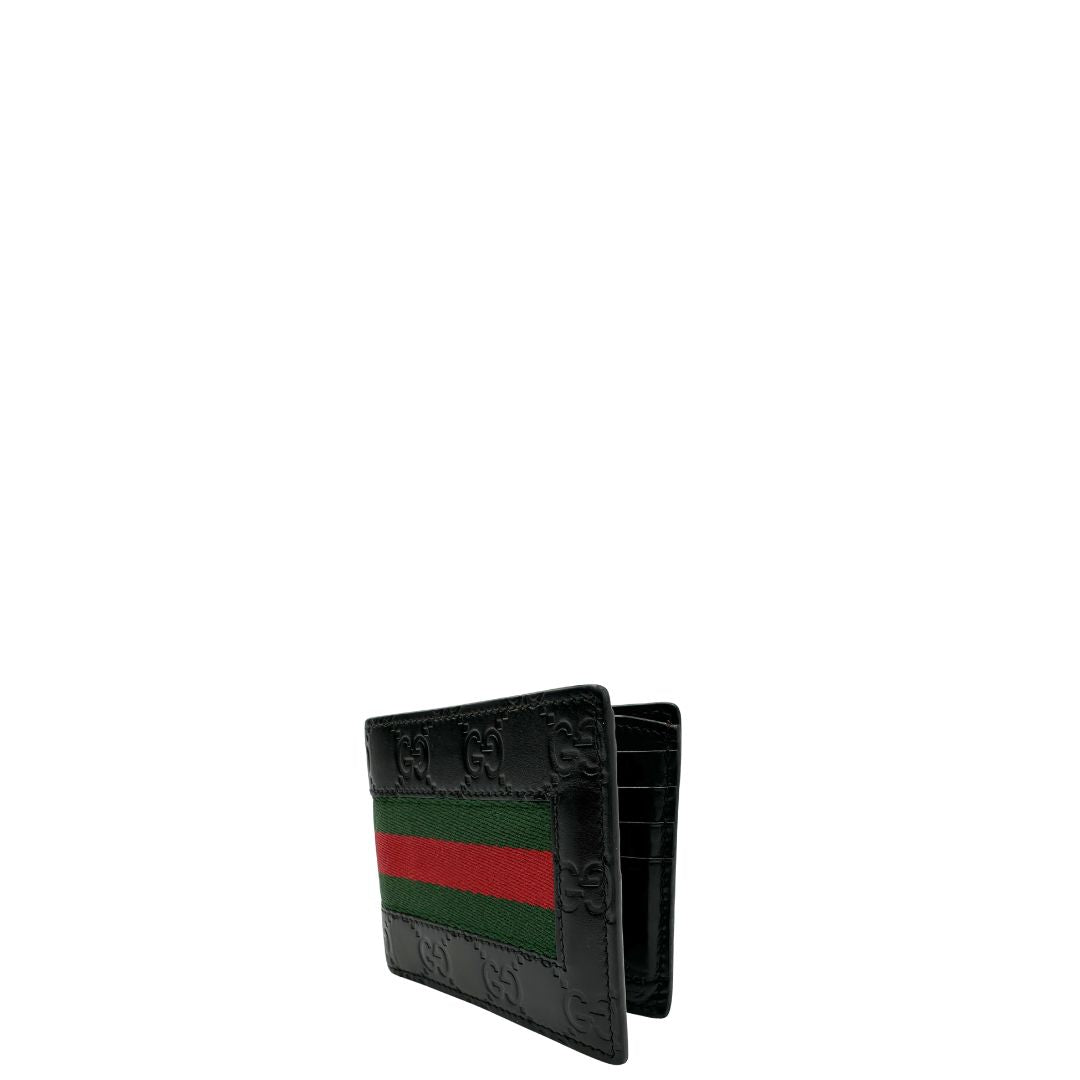 Lato sinistro di un Portafoglio Gucci pelle nera GG impreziosito da striscia Web verde e rossa. Completo di scatola e dustbag. Originale, usata, di lusso, in ottime condizioni.