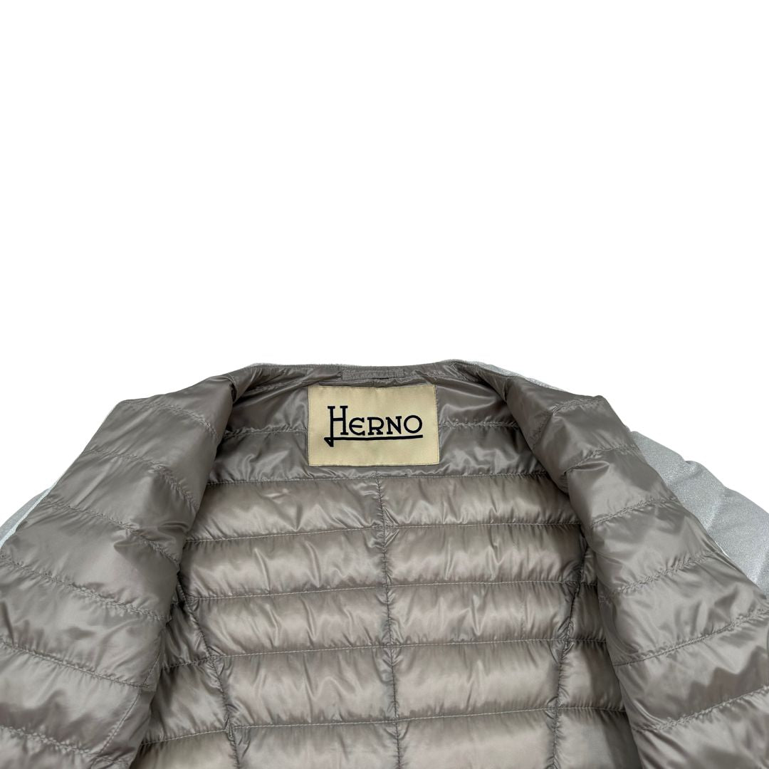 Piumino Herno in 79% poliestere e 21% poliammide argento effetto laminato, munito di due cinture in pelle e catena dorata, di lusso, originale, ottime condizioni, usato