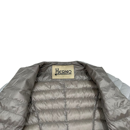 Piumino Herno in 79% poliestere e 21% poliammide argento effetto laminato, munito di due cinture in pelle e catena dorata, di lusso, originale, ottime condizioni, usato