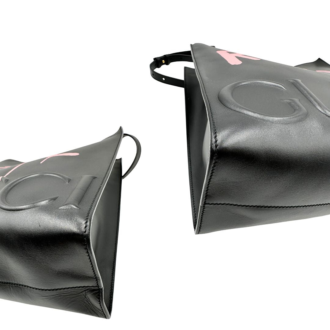 angoli Borsa Gucci in pelle nera con maxi logo tono su tono e dettaglio in rosa; munita di doppi manici e una tracolla regolabile. Completa di dustbag, di lusso, originale, ottime condizioni. 