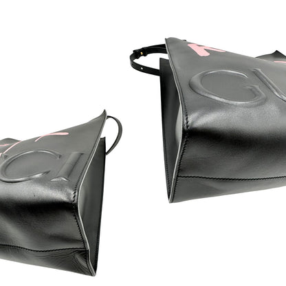 angoli Borsa Gucci in pelle nera con maxi logo tono su tono e dettaglio in rosa; munita di doppi manici e una tracolla regolabile. Completa di dustbag, di lusso, originale, ottime condizioni. 