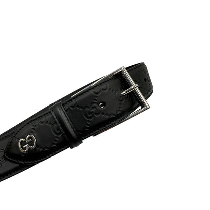 Cintura Gucci in pelle nera GG con parti metalliche argentate.