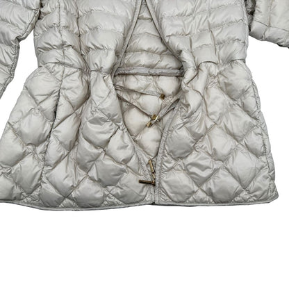 Piumino Max Mara The Cube in 100% poliammide trapuntato, colore avorio perla. Modello con cappuccio, coulisse regolabile in vita e dettagli metallici dorati. Chiusura con zip.