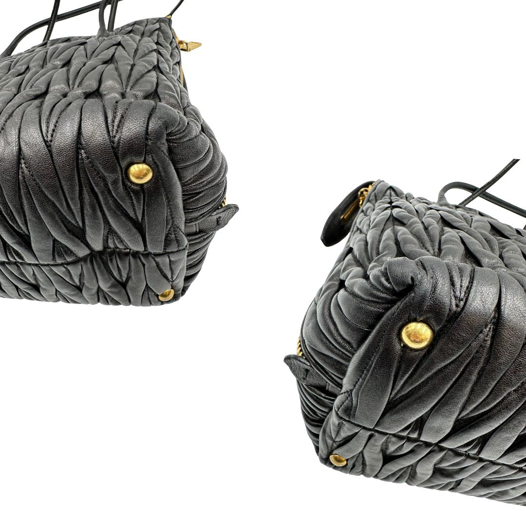 Angoli di una Borsa Miu Miu realizzata in pelle goffrata nera con parti metalliche dorate; munita di due manici stondati, indossabile a spalla. Originale,, usata, di lusso, in ottime condizioni.