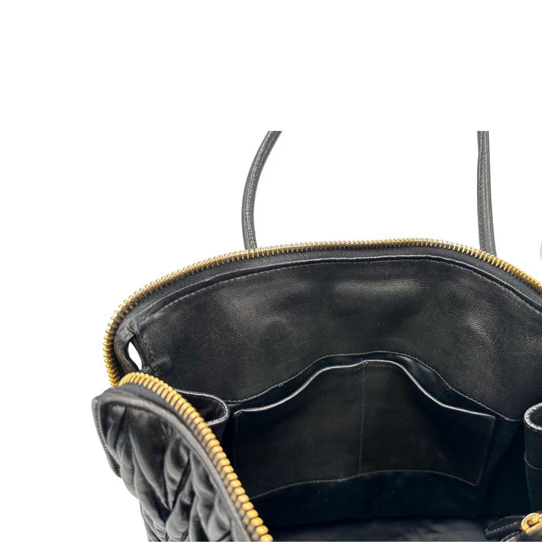 Interno di una Borsa Miu Miu realizzata in pelle goffrata nera con parti metalliche dorate; munita di due manici stondati, indossabile a spalla. Originale,, usata, di lusso, in ottime condizioni.
