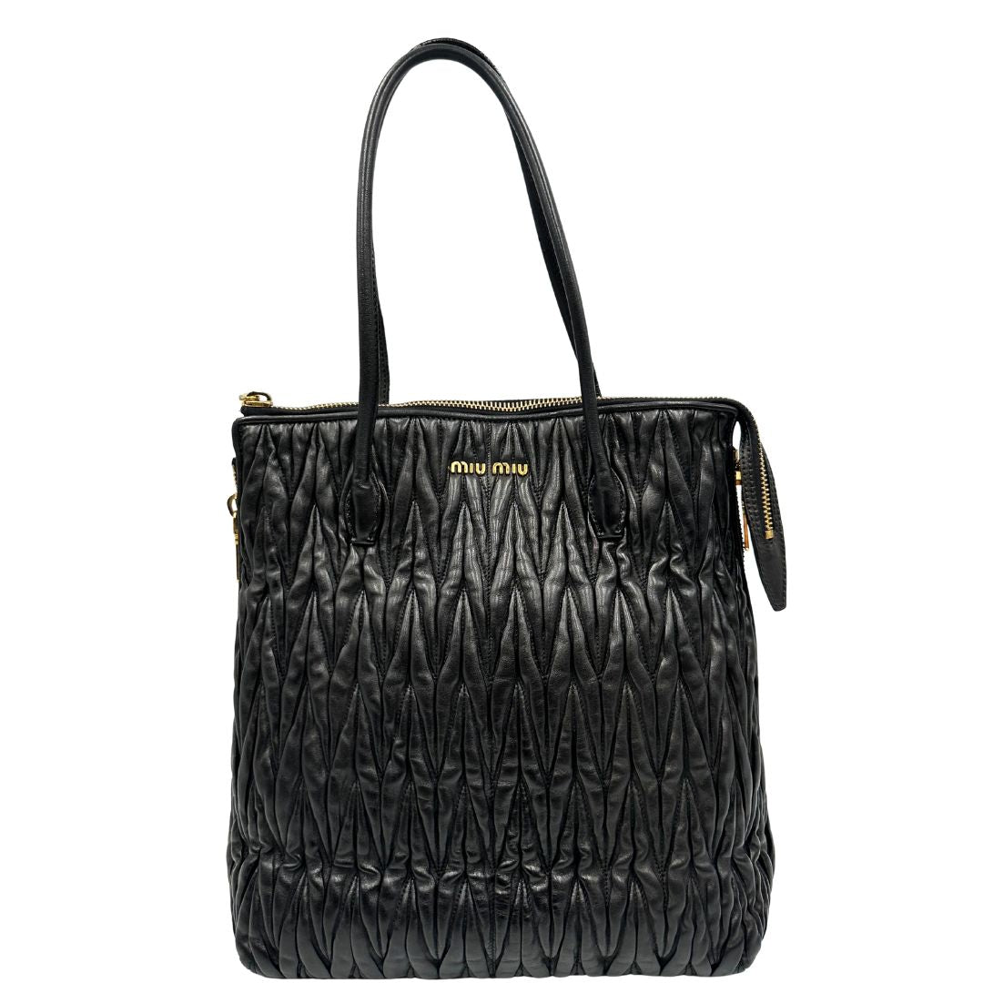 Front di una Borsa Miu Miu realizzata in pelle goffrata nera con parti metalliche dorate; munita di due manici stondati, indossabile a spalla. Originale,, usata, di lusso, in ottime condizioni.