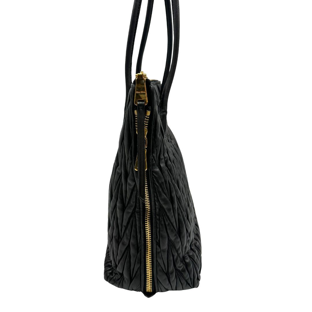Borsa Miu Miu realizzata in pelle goffrata nera con parti metalliche dorate; munita di due manici stondati, indossabile a spalla. Originale,, usata, di lusso, in ottime condizioni.
