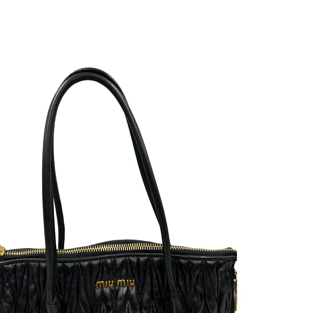 Manici di una Borsa Miu Miu realizzata in pelle goffrata nera con parti metalliche dorate; munita di due manici stondati, indossabile a spalla. Originale,, usata, di lusso, in ottime condizioni.