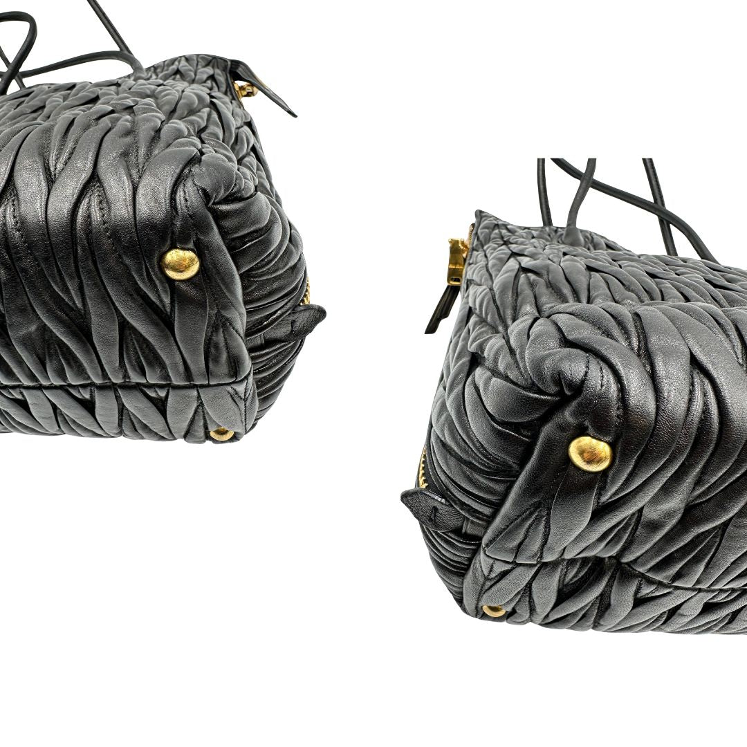 Angoli di una Borsa Miu Miu realizzata in pelle goffrata nera con parti metalliche dorate; munita di due manici stondati, indossabile a spalla. Originale,, usata, di lusso, in ottime condizioni.