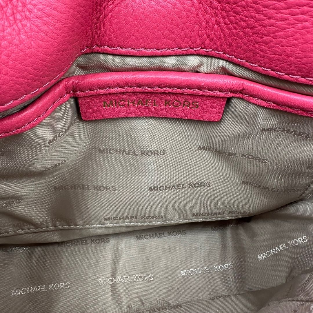interno Borsa MK in pelle fucsia con parti metalliche dorate; munita di una tracolla in catena e pelle regolabile e mini logo sul front. Completa di dustbag, di lusso, eccellenti condizioni, usata. 