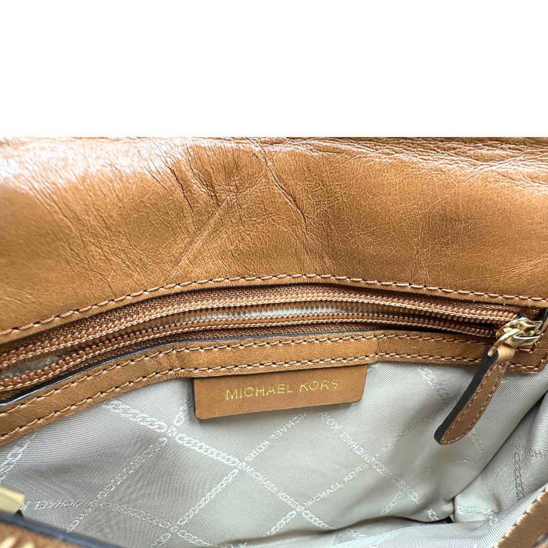 Interno di una Borsa Michael Kors in pelle color cuoio con parti metalliche dorate; munita di una tracolla in catena scorrevole con spallaccio in pelle. Indossabile a tracolla oppure a spalla. Originale, usata, di lusso, in ottime condizioni.