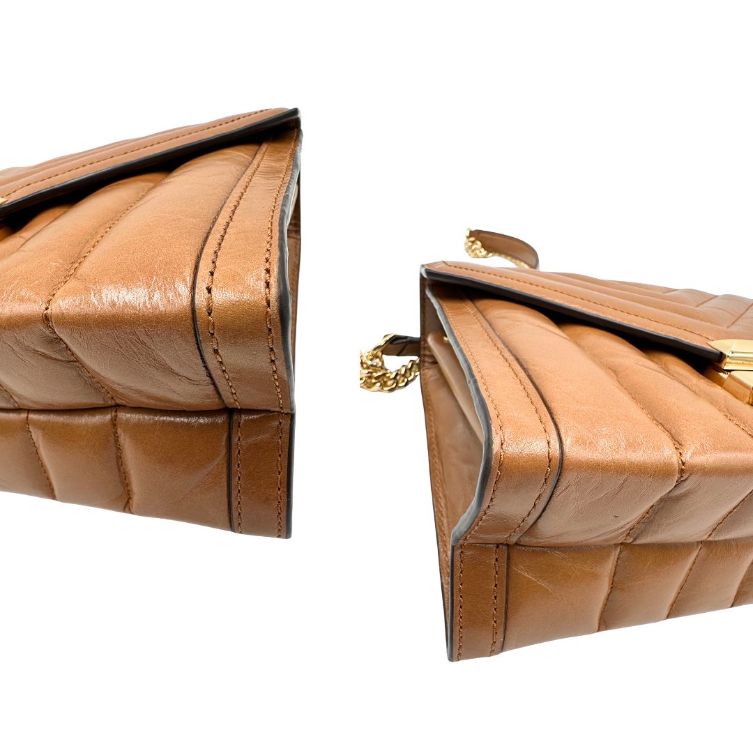 Angoli di una Borsa Michael Kors in pelle color cuoio con parti metalliche dorate; munita di una tracolla in catena scorrevole con spallaccio in pelle. Indossabile a tracolla oppure a spalla. Originale, usata, di lusso, in ottime condizioni.