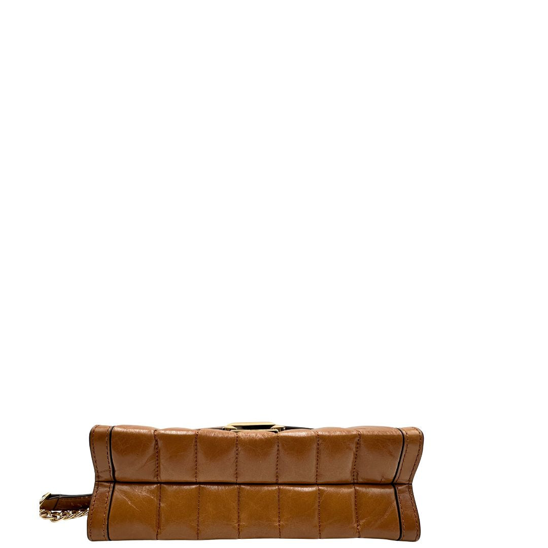 Base di una Borsa Michael Kors in pelle color cuoio con parti metalliche dorate; munita di una tracolla in catena scorrevole con spallaccio in pelle. Indossabile a tracolla oppure a spalla. Originale, usata, di lusso, in ottime condizioni.