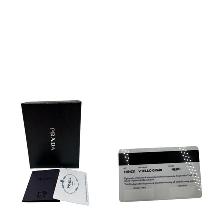 scatola Portafoglio Prada in pelle martellata nera con parti metalliche dorate. Completa di scatola, di lusso, ottime , usata.