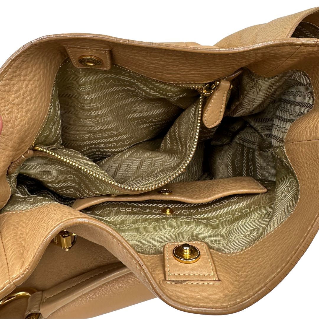 interno Borsa Prada in pelle martellata beige e parti metalliche dorate; munitra di un manico singolo, indossabile a spalla. Completa di dustbag, di lusso, originale, ottime condizioni.  