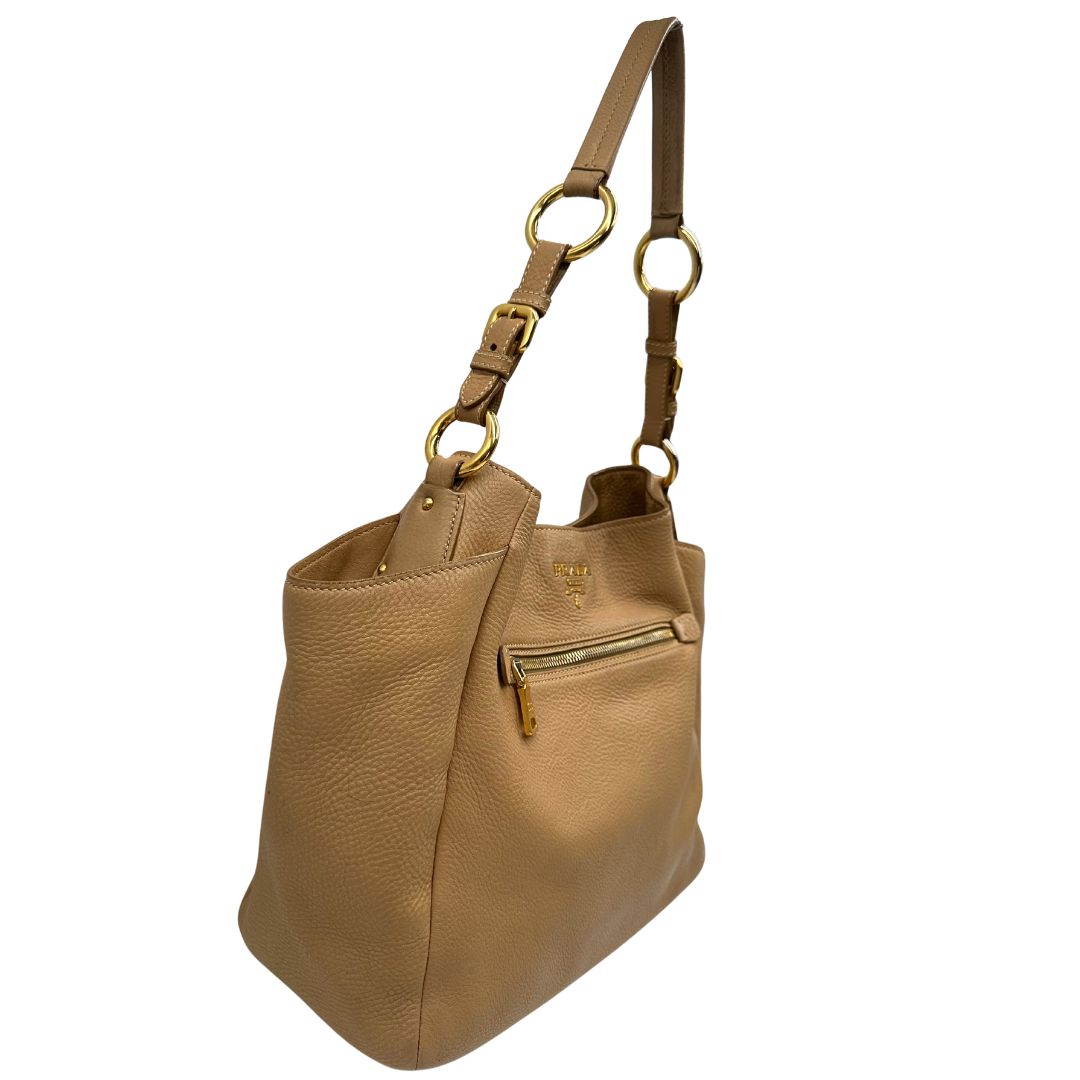 lato Borsa Prada in pelle martellata beige e parti metalliche dorate; munitra di un manico singolo, indossabile a spalla. Completa di dustbag, di lusso, originale, ottime condizioni. 