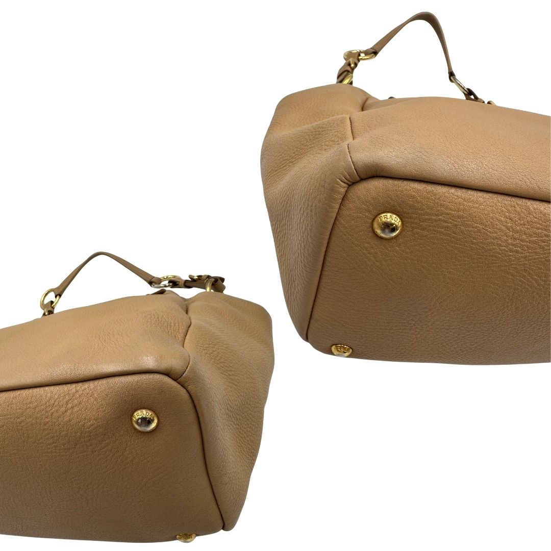angoli Borsa Prada in pelle martellata beige e parti metalliche dorate; munitra di un manico singolo, indossabile a spalla. Completa di dustbag, di lusso, originale, ottime condizioni.