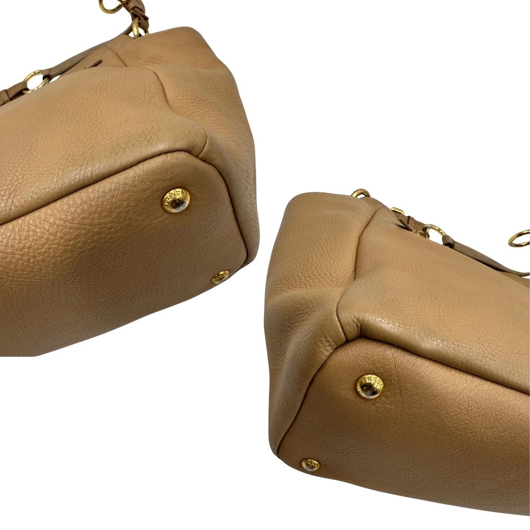 angoli Borsa Prada in pelle martellata beige e parti metalliche dorate; munitra di un manico singolo, indossabile a spalla. Completa di dustbag, di lusso, originale, ottime condizioni. 