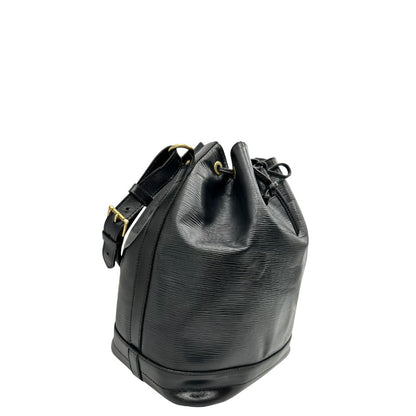 Laterale sinistro di un secchiello Noé Louis Vuitton in pelle Epi nera, con parti metalliche dorate e manico regolabile con fibbia. Indossabile a spalla. Completa di dustbag.