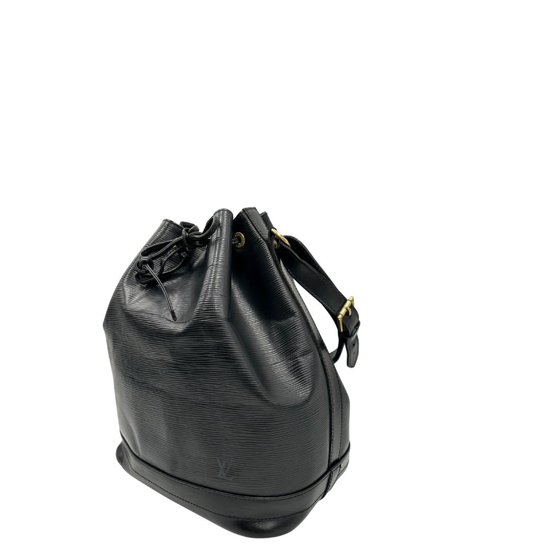 Laterale destro di un secchiello Noé Louis Vuitton in pelle Epi nera, con parti metalliche dorate e manico regolabile con fibbia. Indossabile a spalla. Completa di dustbag.