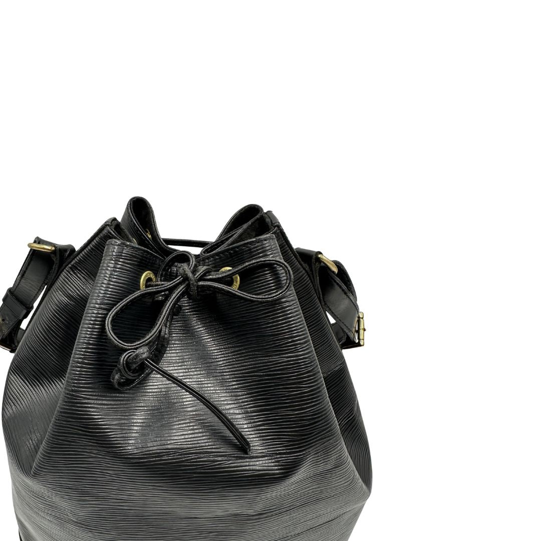 Chiusura a coulisse di un secchiello Noé Louis Vuitton in pelle Epi nera, con parti metalliche dorate e manico regolabile con fibbia. Indossabile a spalla. Completa di dustbag.