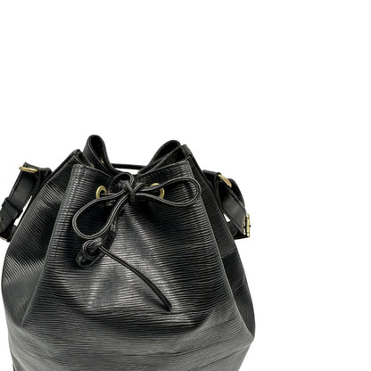 Chiusura a coulisse di un secchiello Noé Louis Vuitton in pelle Epi nera, con parti metalliche dorate e manico regolabile con fibbia. Indossabile a spalla. Completa di dustbag.