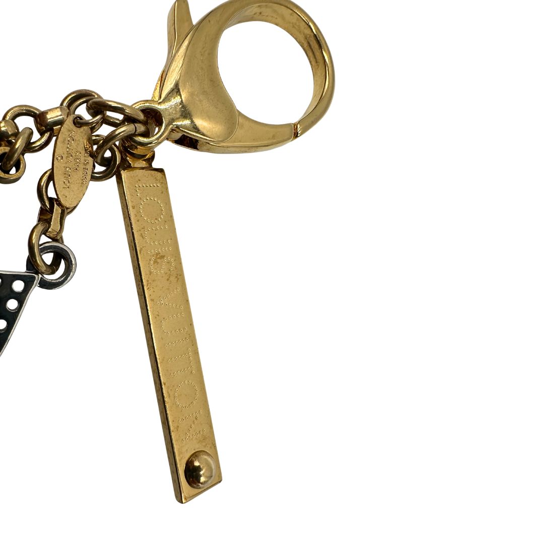 Charm Louis Vuitton in metallo argentato e dorato con iconica forma del classico fiore della maison. Full set, di lusso, originale, usato.