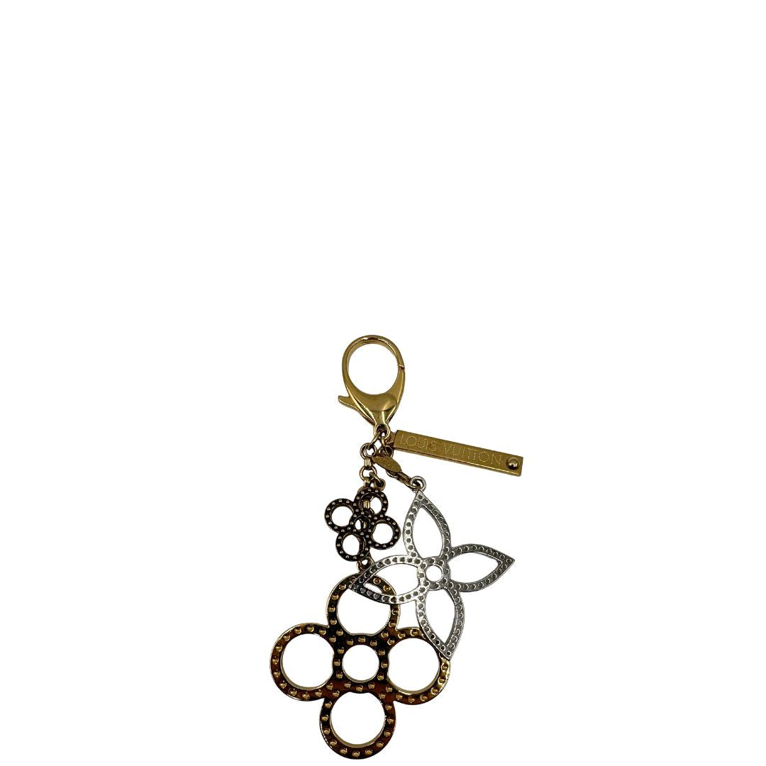 Charm Louis Vuitton in metallo argentato e dorato con iconica forma del classico fiore della maison. Full set, di lusso, originale, usato.