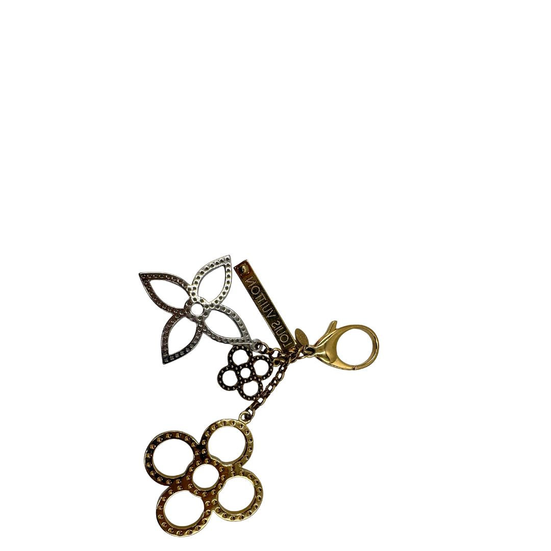 Charm Louis Vuitton in metallo argentato e dorato con iconica forma del classico fiore della maison. Full set, di lusso, originale, usato.