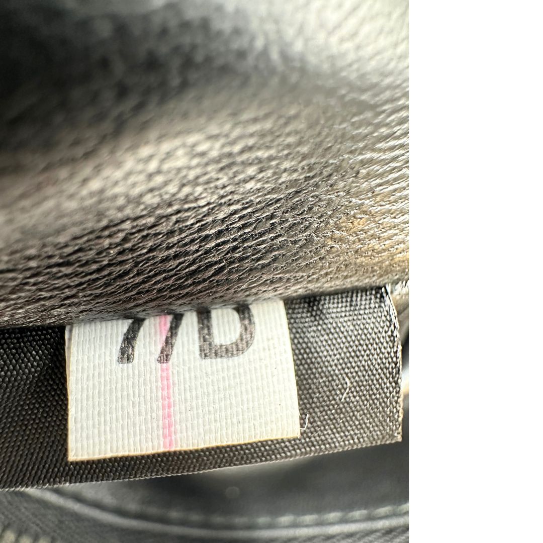 Codice di una Pochette Prada in pelle marrone cognac con parti metalliche argentate, presenta un motivo intrecciato nella parte superiore, munita di una pochette estraibile in pelle nera con logo lettering sul front. Originale, usata, di lusso, in ottime condizioni.