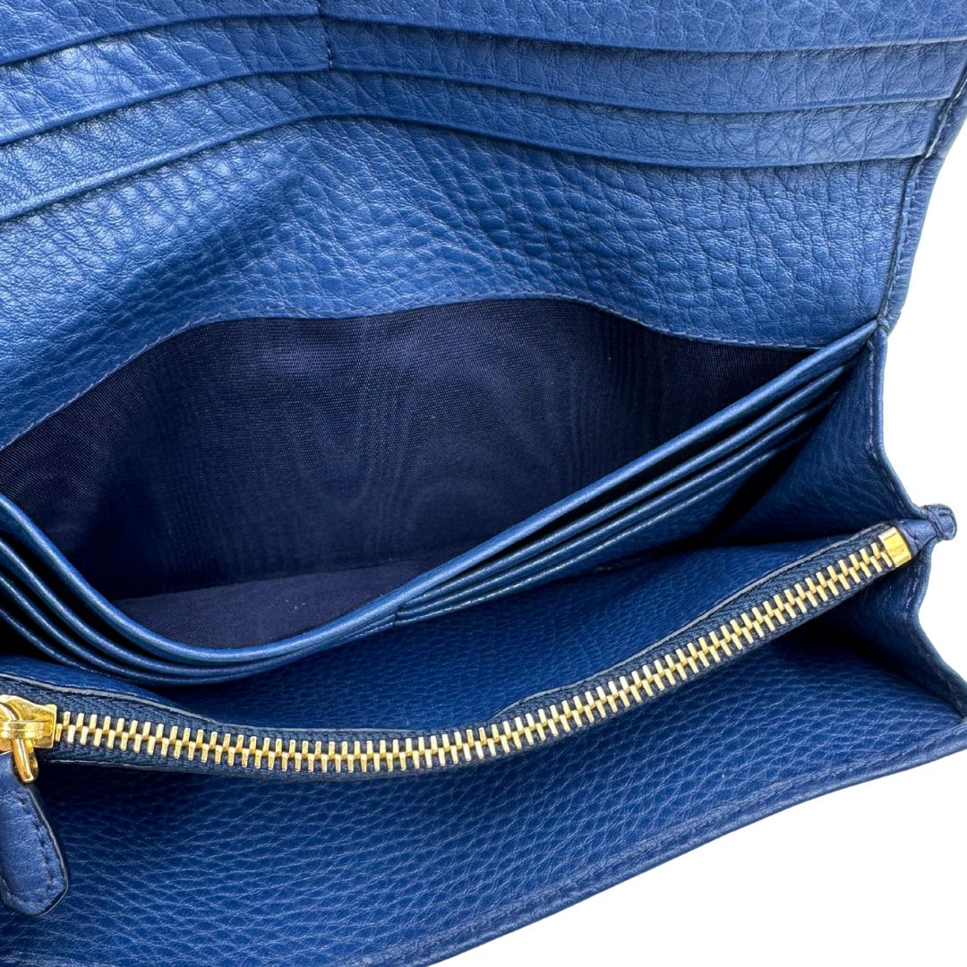 Portafoglio Prada in pelle blu martellata con parti metalliche dorate. Completo di dustbag, di lusso, originale, ottime condizioni, usata.