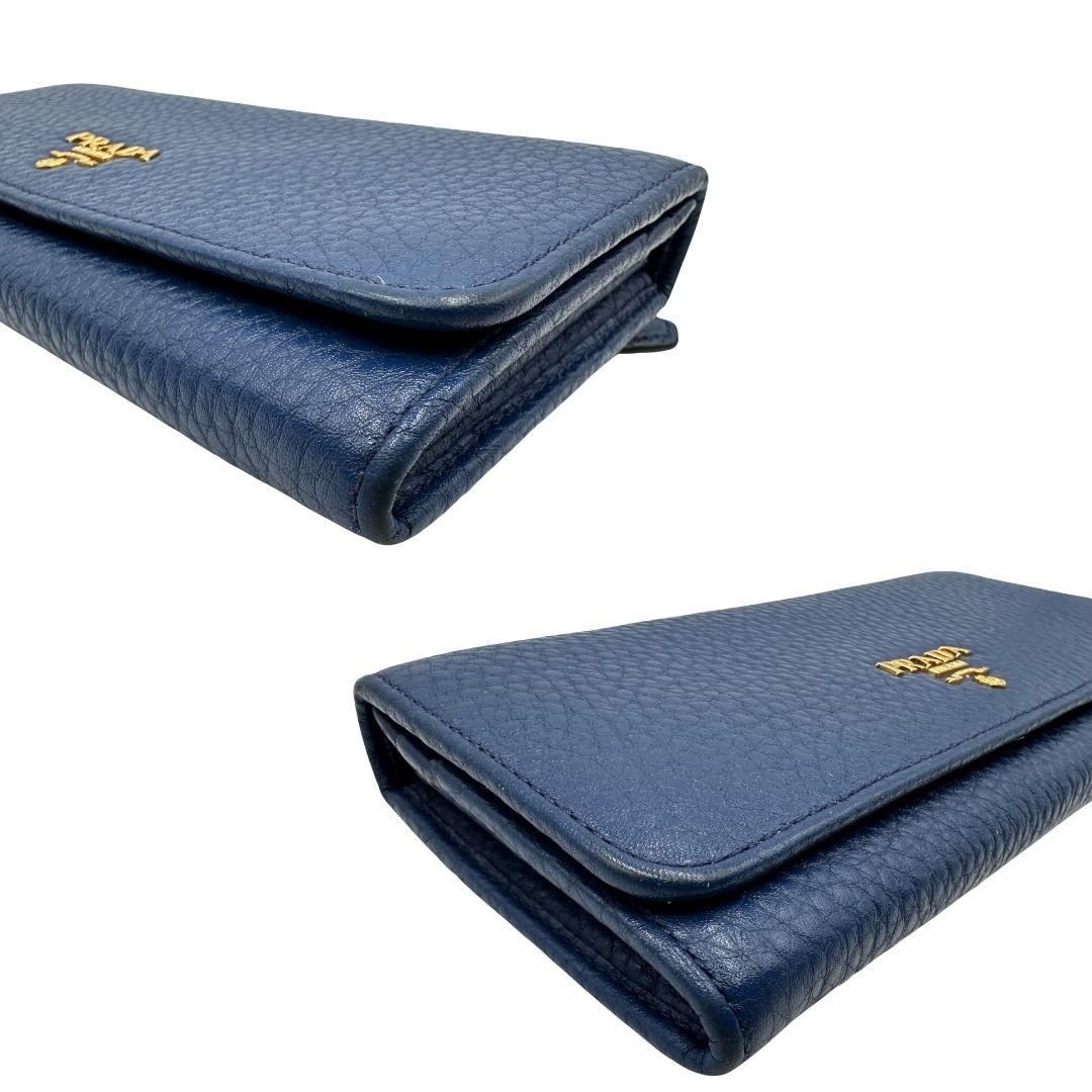 lato Portafoglio Prada in pelle blu martellata con parti metalliche dorate. Completo di dustbag, di lusso, originale, ottime condizioni, usata. 