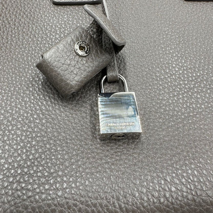 lucchetto Borsa Saint Laurent in pelle martellata grigia con parti metalliche argentate; munita di doppi manici stondati e una tracolla amovibile. Impreziosita da un lucchetto decorativo, di lusso, originale, ottime condizioni. 