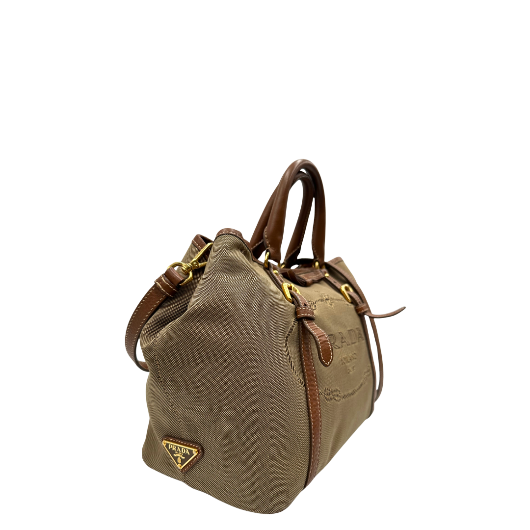 lato  Borsa Prada in tessuto Jacquard, finiture in pelle marroni e parti metalliche dorate; munita di doppi manici e una tracolla amovibile e regolabile. Completa di dustbag, di lusso, originale, ottime condizioni. 